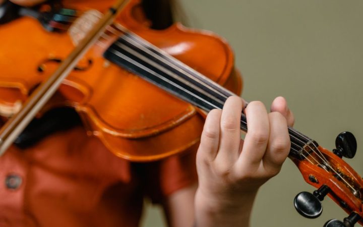 Young student playing the violin during a private lesson with an instructor