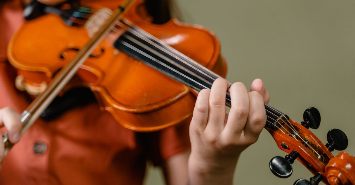 Young student playing the violin during a private lesson with an instructor