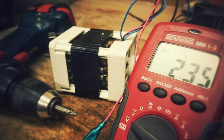Close-up of a digital multimeter screen displaying voltage measurements during an electrical check.