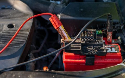 Mechanic attaching jumper cables to a car battery