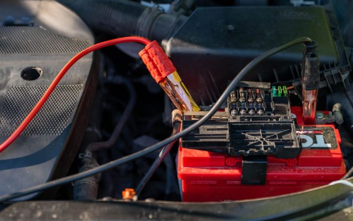Mechanic attaching jumper cables to a car battery