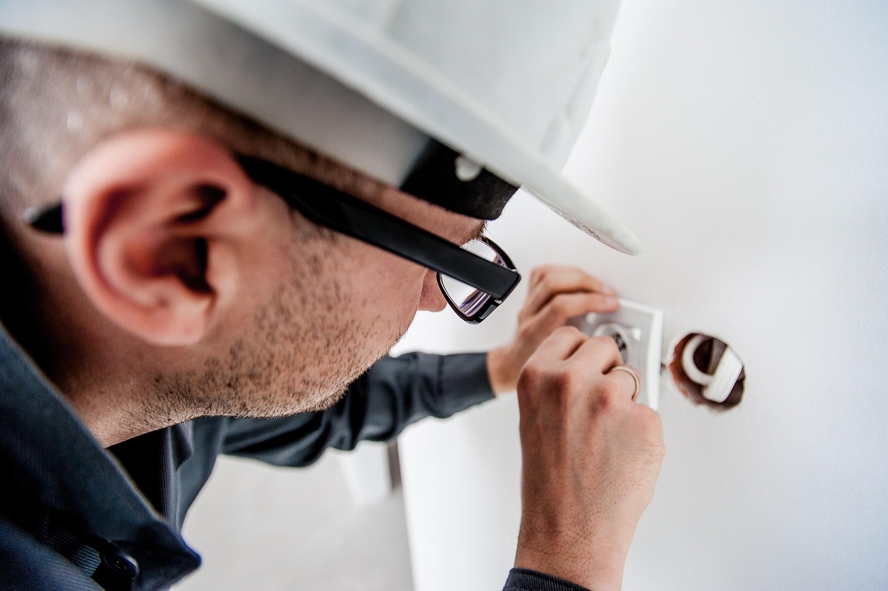 A technician testing the compressor and internal components of an air conditioning unit.
