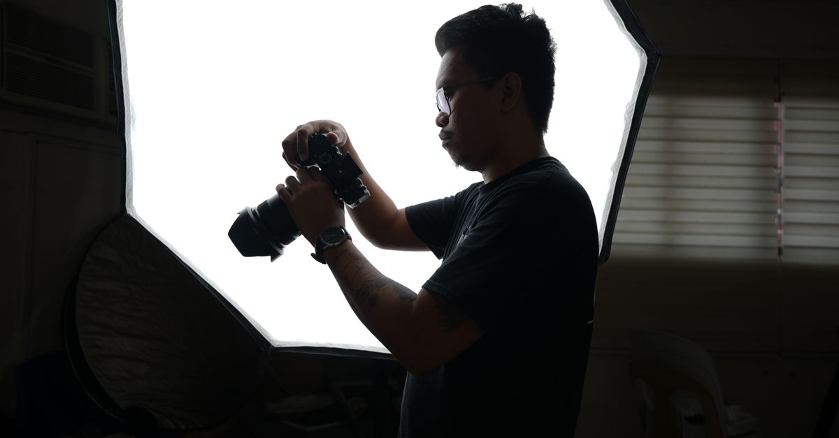 A creator assembling a large softbox in a professional studio space.