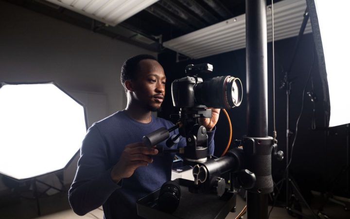 A photographer inspecting the internal components of a professional studio strobe light.