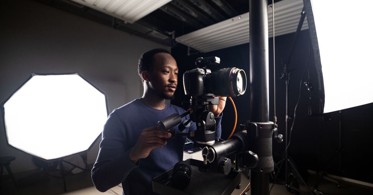 A photographer inspecting the internal components of a professional studio strobe light.