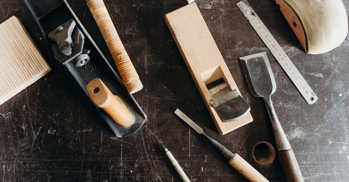 A mechanic servicing woodworking machinery in a professional repair shop.