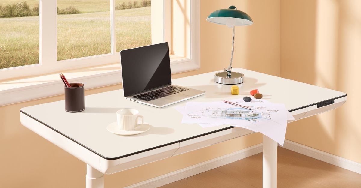 Remote worker adjusting the height of a motorized standing desk.