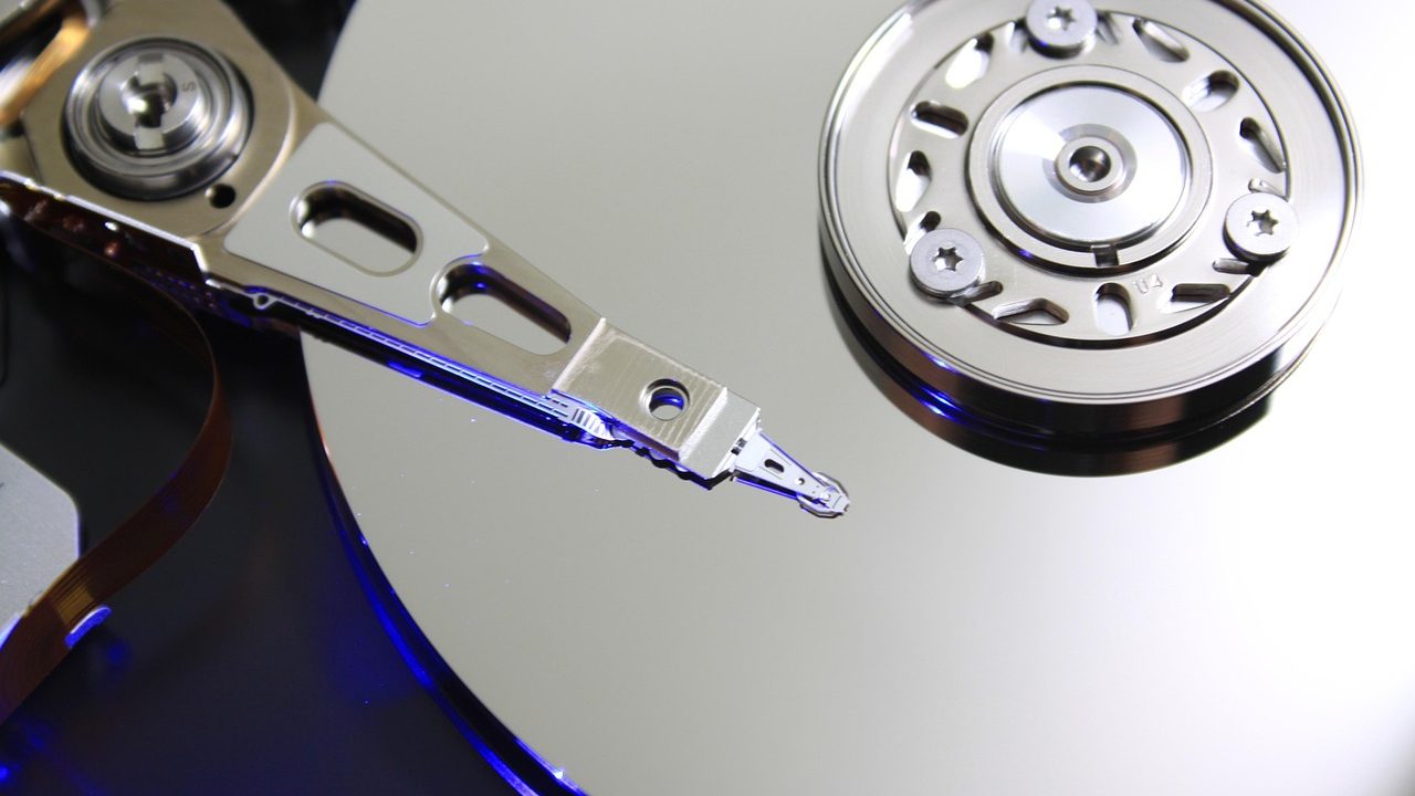 Home office professional installing a battery backup unit under a wooden desk.